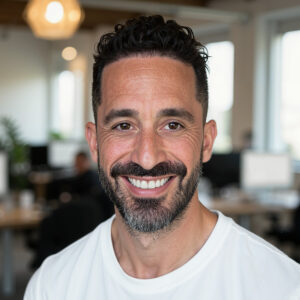 Portrait of Nicholas Statman smiling in an office enviroment.