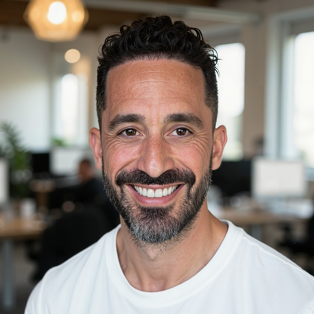 Portrait of Nicholas Statman smiling in an office enviroment.